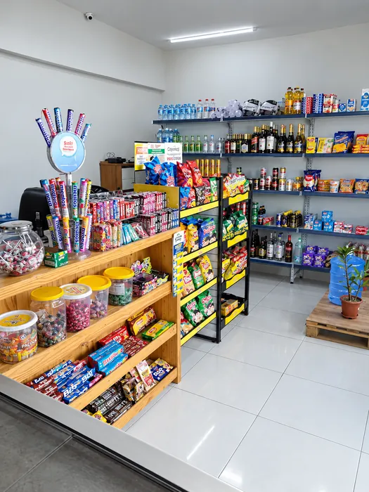 Interior da TEB Conveniência com balcão de doces, prateleiras de bebidas e expositores de salgadinhos