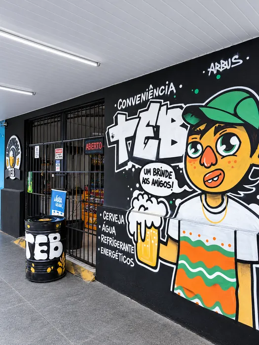 Mural da fachada da TEB Conveniência com a frase Um brinde aos amigos e um personagem ilustrado